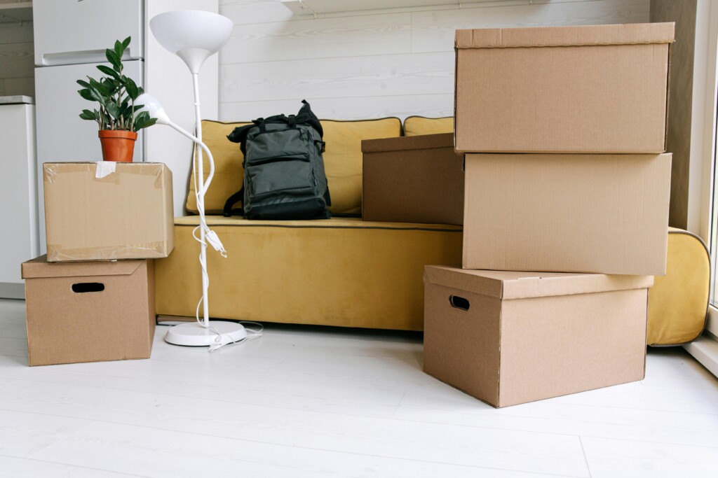 شركة نقل عفش بحي شوران بالمدينة المنورة: دليلك الكامل للانتقال الآمن Cardboard boxes and a backpack in a cozy living room signify moving day excitement.